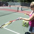  Julia Coffman works with tennis players Thursday during the 18th annual Cancer Challenge Junior Ten...