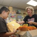  Grimes Elementary studetn Ezekiel Salas gets summer reading material from Grimes librarian Linda Je...