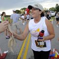  Brandy Wills of Gentry, center, is handed a cold towel by volunteer Rachael Corley after completing...