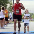  Kristian Downey, 6, of Bentonville, right, reacts as he crosses the finish line with his father Jon...