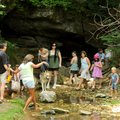 People find the coolest spot in front of the cave at Blowing Springs from which to listen to live mu...