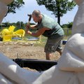 Shawn Brown, with RJR Enterprises of Rogers, installs playground equipment on Friday at Apple Glen E...