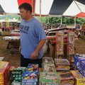 Alan Hardcastle, with Phoenix Fireworks, goes over inventory Sunday at the tent east of Rogers on U....