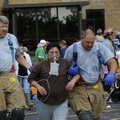 Springdale firefighters help a woman to an ambulance outside the Tyson Foods plant on Berry Street i...