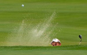Mason Adams of Fayetteville knocks his ball out of the sand trap onto the 18th green Monday afternoon during the first round of the USGA Jr. Amateur Qualifer golf tournament at Blessings golf course.