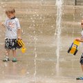 Nicholas Graziani, 3, left, and his twin brother Zachary play on the splash pad at Lawrence Plaza in...