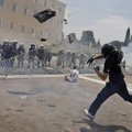A protester throws a garbage bag to riot police in front of the Greek Parliament during clashes in c...