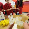 Ross Shirey, left, and Amanda Thompsen pour lemonade Wednesday during a Young Scholars program spons...