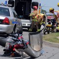 Springdale firefighters treat a patient Wednesday after a three-vehicle accident involving a motorcy...