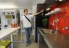 Chris Baribeau talks on June 7 about the features in the EcoModern Flats at 130 S. Hill Ave. in Fayetteville. Concrete countertops and floors require less maintenance.