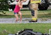An unidentified woman pleads with Springdale Fireman Cody Keller after emergency personal tried to revive a victim in a motorcycle accident July 7, 2010 on County Line Road in Springdale. Michael Wolf died at the scene.