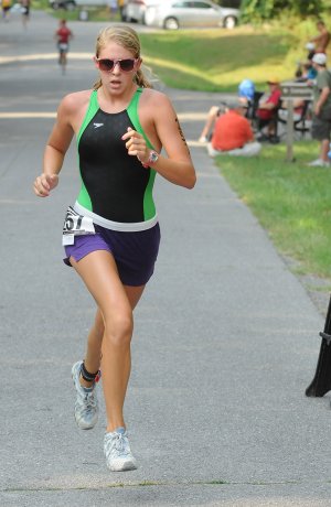 Lauren Tininenko, 18, from Bentonville hits the finish line in the Sharkfest V Sprint Triathlon at Horseshoe Bend on Beaver Lake on Sunday. Tininenko finished third in the female overall open division with a total time of 1:19:00.4.