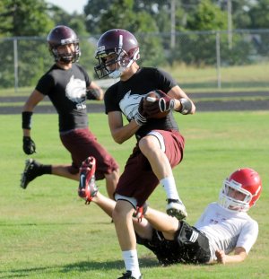 Lincoln’s Danny Calvillo catches a pass Monday as a Farmington defender falls to the ground during a 7-on-7 competition in Gravette.