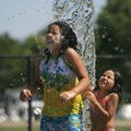 Stephanie Aguilar, 10, and her sister Jackelin Aguilar, 6, both of Rogers, cool off Tuesday morning ...