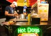 Cody Yancey serves hot dogs and drinks Friday from his cart on West Dickson Street in Fayetteville.