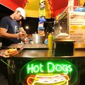 Cody Yancey serves hot dogs and drinks Friday from his cart on West Dickson Street in Fayetteville.