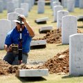 Bert Brawner of Drasco uses surveying equipment Tuesday to realign headstones at the Fayetteville Na...