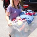 Volunteers Rebekah Egle, right, and Hannah Johnson carry in clothing donated Tuesday for the First B...