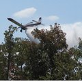 A private plane under contract with the Arkansas Forestry Commission drops water on a grass fire Tue...
