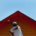 Billy Campbell with Noah’s Ark Painting paints eaves on the Pretty Pets Grooming building Tuesday on...