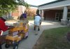 Little Rock School District employees move carts with boxes of school supplies that members of the Junior League of Little Rock donated to Stephens Elementary pupils as part of the league’s Stuff the Bus program. 