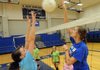 Alex Jacobs, assistant coach for the Rogers High School volleyball team, right, runs the team through drill during practice Wednesday at the school in Rogers.