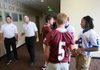   Benton Head Coach Scott Neatheri (left) talks with Bryant Head Coach Paul Calley as their players', Benton's Brooks Balisterri (left) and Caleb Davis (center, front) meet Sawyer Nichols (center,back) and Dillion Winfrey (far right) at an event Friday to promote the Salt Bowl. the bowl is a game between the two schools and will be Sept. 2, at War Memorial Stadium.