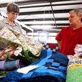 Volunteers Judy Bell (left) and Shirley Sands, both of Cave Springs, check quilting entries Monday b...