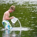 Tyler Couch, 11, of Middleton, Idaho, lifts a small fish he caught in a plastic bag Monday in Little...