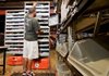 Daniel Collins pulls merchandise from shelves at the Acumen Brands Inc. distribution center in Fayetteville that were delivered to him by a Kiva Systems Inc. robot, seen below the shelves. 