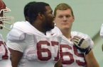   University of Arkansas offensive linemen Alvin Bailey (left) and Mitch Smothers get ready to run drills during practice at the University of Arkansas.
