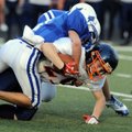 Rogers’ Justice Thompson tackles Rogers Heritage’s Tim Cole on Tuesday at Mountie Stadium in Rogers.