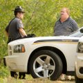 Sgt. Andrew Oliver, left, of the Benton County Sheriff’s Office waits Tuesday with a handcuffed man ...