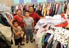 Silvia and Arturo Garcia of Springdale volunteer with their sons, Pablo, 7, and Rodrigo, 12, at LifeSource International Inc. in Fayetteville after receiving aid from the agency in the wake of Arturo losing his job unexpectedly.
