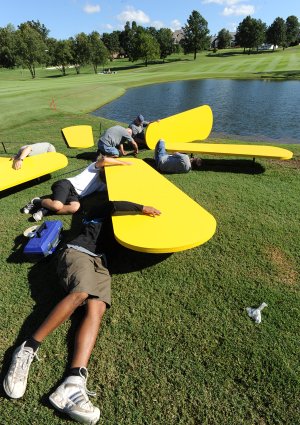 Workers assemble a floating Walmart logo before installing it in a water hazard along the 18th fairway Monday while preparing for this week’s LPGA Walmart NW Arkansas Championship at Pinnacle Country Club in Rogers.