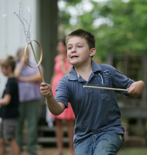 Eli Denham, 8, of Fayetteville plays graces at the Shiloh Museum in Springdale. The game was created to teach agility, poise and grace to children in the 18th century. 