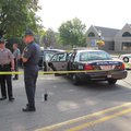 Law enforcement personnel stand Tuesday near the Van Buren police car of officer Dave Passen at the ...