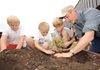 GARDEN PREP — Mayor Lioneld Jordan, right, helps to plant a small container garden Thursday with Butterfield Trail Elementary School Garden Club members, from left, Gray Robinson, Coty Barnes and Males Lerz, all fifth-graders at the school, during a dedication ceremony for the school’s new wildlife habitat and rain garden at the school.
