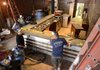 Workers with Tri-City Granite install a counter Thursday at The Pressroom in downtown Bentonville. Owners Robert and Bea Apple hope to open the coffee bar in October. Rob Apple said the coming of Crystal Bridges and the spirit of growth it sparked prompted the couple to move from Fayetteville and open an espresso cafe on Central Avenue next door to City Hall.
