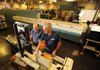 Bill Ogryzek, left, and Eddie Samuels, both electronics technicians for the Postal Service, perform preventive maintenance Friday on a sorting and labeling machine before mail sorting begins at the postal facility in Fayetteville.
