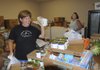 Lisa Barczewski, left, and Lisa Heffron work Tuesday at the St. Vincent de Paul Outreach Center in Rogers. The food pantry is one of several community services provided by the Society of St. Vincent de Paul.