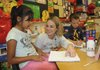 Susan Hill, a second-grade teacher at Jones Elementary School in Rogers, helps Jasimine Jimenez, left, and Alexis Pintor with a math lesson Friday.

