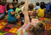 Jordan Herzberg, Root Elementary School first-grader, raises her hand to ask a question Thursday as assistant teacher Cory White talks about herbivores, carnivores and omnivores during a science lesson in Fayetteville.