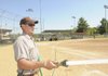 Bentonville city worker Chris Little hoses down a softball field at Memorial Park on Thursday.
