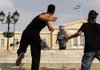  A demonstrator hurls a stone toward the Greek Parliament building in Athens, where at least 16,000 people gathered Wednesday to protest austerity measures designed to obtain international bailout funds. 