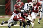Auburn running back Onterio McCalebb (23) is stopped by Arkansas safety Jerico Nelson (31), safety Tramain Thomas (5), and cornerback Tevin Mitchel (8) during the first half of the NCAA college football game in Fayetteville, Ark., Saturday, Oct. 8, 2011.