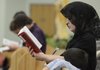 Jacqueline Harbaugh of Rogers reads the Latin-English missal for praying the traditional Mass during a Tridentine Mass on Sept. 18 at St. Joseph Catholic Church in Tontitown.
