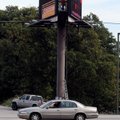 SIGN OF THE TIMES An employee of Ashby St. Outdoor makes adjustments earlier this week to a digital ...