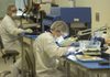 Austin Nelson, right, and Herman Joiner work Tuesday in a lab at Arkansas Power Electronics International making the internal components for power circuits.

