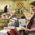 BOOK BENEFIT Jacqualynn Garrison of Bentonville looks through a stack of books Saturday during the F...